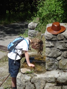 Catherine's son cools down under a water pump while hiking in Alpes early May during unexpected heatwave